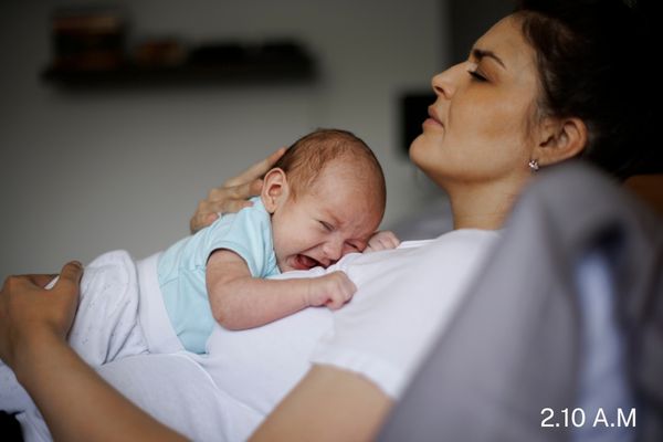 new mom with newborn baby at night setting up diaper station